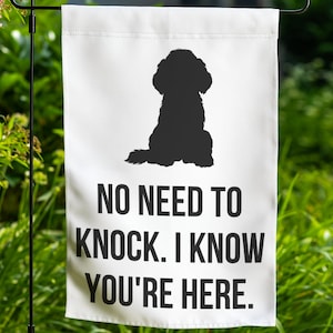 May include: White garden flag with a black silhouette of a dog sitting. The text "NO NEED TO KNOCK. I KNOW YOU'RE HERE." is printed below the dog.