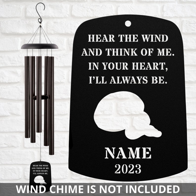 Może przedstawiać: Czarny metalowy wieszak na dzwonki wiatrowe z tekstem "Hear the wind and think of me. In your heart, I'll always be." i kształtem chmury z tekstem "NAME 2023". Dzwonki wiatrowe nie są wliczone w cenę.