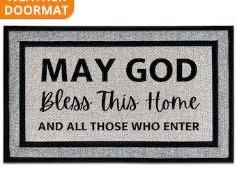May include: Rectangular all-weather doormat with a gray woven texture. The mat features a black border and the text "MAY GOD Bless This Home AND ALL THOSE WHO ENTER" in black. An orange banner in the top left corner reads "ALL WEATHER DOORMAT".