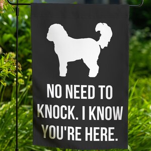 May include: Black and white garden flag with a silhouette of a dog and the text "NO NEED TO KNOCK. I KNOW YOU'RE HERE."