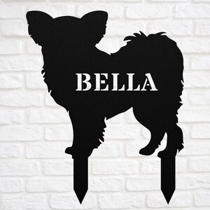 May include: Black metal silhouette of a Chihuahua dog with the name "BELLA" on the body. The silhouette is on two metal stakes for inserting into the ground.