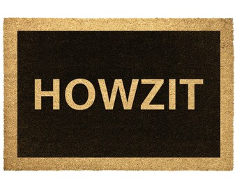 May include: A brown coir doormat with a black border and the word "HOWZIT" in white lettering.
