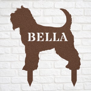 May include: Brown metal silhouette of a dog with the name "BELLA" printed on the side. The silhouette is on two stakes, ready to be placed in the ground.