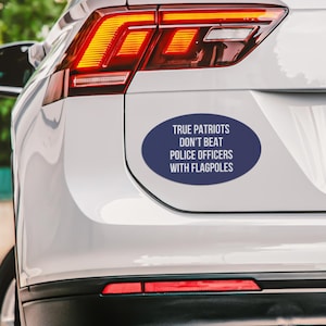 May include: A blue oval car sticker with white text that reads "TRUE PATRIOTS DON'T BEAT POLICE OFFICERS WITH FLAGPOLES".