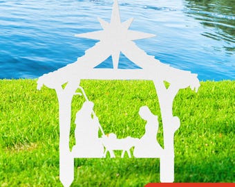 May include: White silhouette of the nativity scene with Mary, Joseph, and baby Jesus in a manger. The scene is set against a green grassy background with a blue lake in the background. The words "5 SIZES" are printed in red at the bottom of the image.