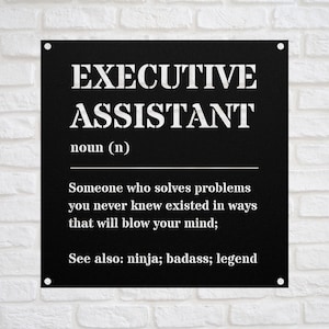 May include: Black metal sign with white text defining "Executive Assistant" as someone who solves problems you never knew existed in ways that will blow your mind. The sign also lists "ninja; badass; legend" as synonyms.