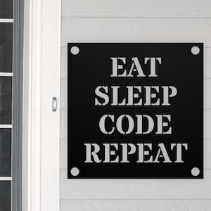 May include: Black metal sign with white text that reads "Eat Sleep Code Repeat".