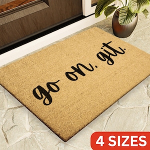 May include: A brown coir doormat with the text "go on. git." in black lettering. The doormat is available in four sizes.