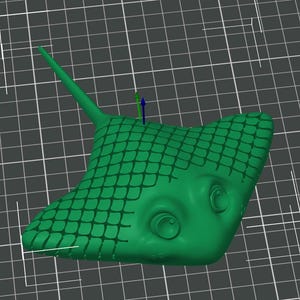 May include: A green, stylised stingray figurine with a textured, scale-like pattern on its back. The figurine has large, cartoonish eyes and a long, pointed tail. The background is a grid.