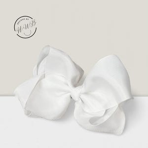 May include: A large, white hair bow made of ribbed grosgrain ribbon. The bow is centered and has a classic shape, with multiple loops and tails. The image includes the text "DESIGNS BY HWB" in a circular logo.