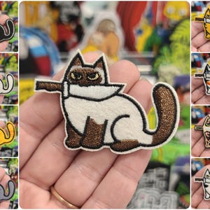 May include: A set of 10 iron-on patches featuring different cats holding knives. The cats are in various colors and patterns, including black, white, orange, and brown. The patches are perfect for adding a touch of whimsy to clothing, bags, or other accessories.