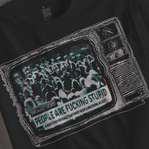 Può includere: Una t-shirt nera con una grafica bianca di un televisore vintage. Lo schermo mostra una folla con un effetto glitch e il testo: BREAKING NEWS, PEOPLE ARE FUCKING STUPID, A NEW STUDY REVEALS THAT MOST PEOPLE ARE DUMB AS SHIT.
