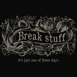 May include: Black graphic design with the words "Break stuff" in a banner, surrounded by ornate scrollwork and floral elements. Below the banner, the text reads "-it's just one of those days-".