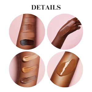 May include: Four swatches of foundation on a person's arm, showing different shades of brown. The swatches are arranged in a vertical line, with the darkest shade at the bottom and the lightest shade at the top. The person's arm is on a pink background.