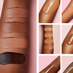 May include: A close-up of a person's arm with swatches of different shades of foundation makeup. The swatches are arranged in a vertical line, starting with the lightest shade at the top and getting progressively darker towards the bottom. The swatches are applied to the skin in a smooth, even layer.
