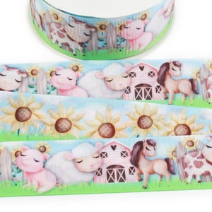 May include: A blue and green ribbon with a repeating pattern of farm animals, including a cow, pig, sheep, horse, and sunflowers. The animals are cartoon-like and have a whimsical style.