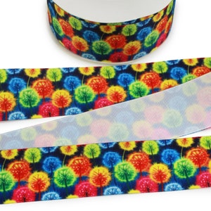 May include: A close-up of a colorful ribbon with a repeating pattern of rainbow-colored dandelions on a dark blue background. The ribbon is shown rolled up and unrolled.