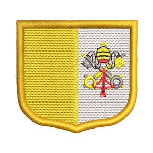 Könnte beinhalten: Ein gelber und weißer gestickter Aufnäher in Form eines Schildes. Der Schild hat auf der linken Seite einen gelben Hintergrund und auf der rechten Seite einen weißen Hintergrund. Die weiße Seite zeigt ein silberfarben gesticktes päpstliches Wappen mit einem roten und gelben Schlüssel.