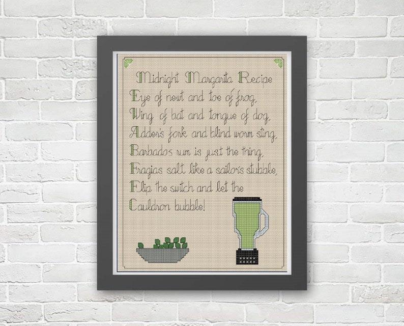 May include: A framed cross-stitch pattern with a beige background and green text. The text reads "Midnight Margarita Recipe" and includes a list of ingredients. The image also includes a green blender and a bowl of green peas.