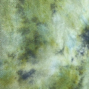 K&ouml;nnte beinhalten: Nahaufnahme eines gr&uuml;nen und braunen Stoffes mit einer strukturierten Oberfl&auml;che. Der Stoff hat ein Batik-Muster in Gr&uuml;n-, Braun- und Wei&szlig;t&ouml;nen.
