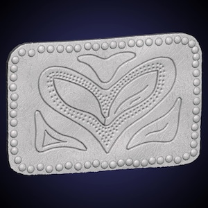 May include: A rectangular, silver-colored belt buckle with a textured surface. The buckle features a central heart-shaped design with leaf-like details and a dotted border. The edges are lined with small, raised circular accents.
