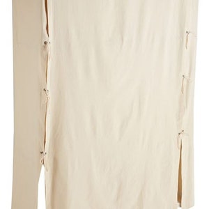 May include: A white cotton garment cover with ties and a zipper closure. The cover is designed to protect furniture or other items from dust and dirt.