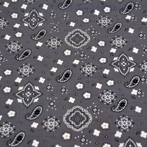 May include: A gray fabric with a white paisley pattern. The fabric is covered in a repeating pattern of paisley shapes, diamonds, and small flowers.