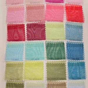 May include: A color chart of sheer fabric swatches in various shades of pink, red, green, blue, and yellow. The swatches are labeled with numbers and color names.