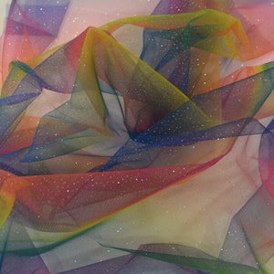 May include: Rainbow tulle fabric with silver glitter. The fabric is folded and draped, showing the different colors of the rainbow.