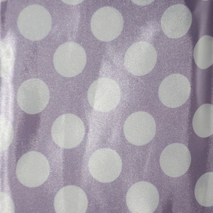 May include: Purple fabric with a white polka dot pattern. The fabric has a satin sheen.