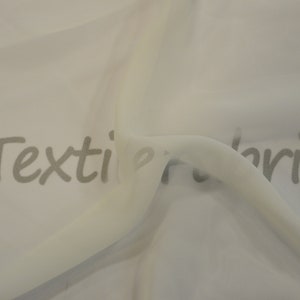 May include: White sheer fabric with a slight sheen. The fabric is folded and draped, showing its texture. The text "myTextileFabric.com" is printed on the fabric.