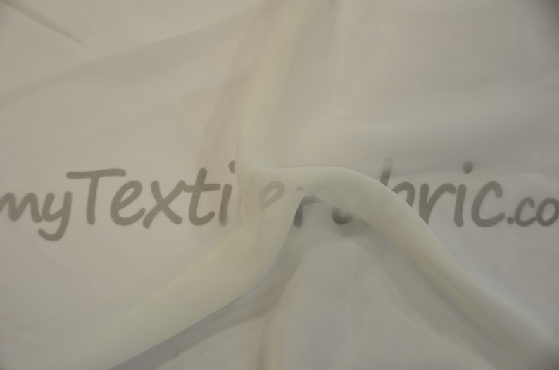 May include: White sheer fabric with a slight sheen. The fabric is folded and draped, showing its texture. The text "myTextileFabric.com" is printed on the fabric.