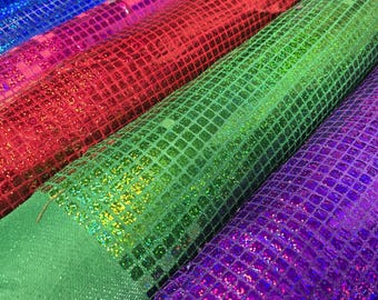 May include: Four rolls of iridescent fabric with a square pattern. The fabric is blue, red, green, and purple.