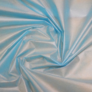 May include: A close-up of a light blue fabric with a subtle grid pattern. The fabric is wrinkled and folded, creating a soft, flowing texture.