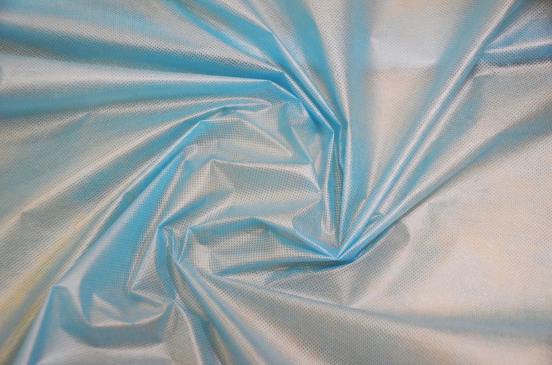 May include: A close-up of a light blue fabric with a subtle grid pattern. The fabric is wrinkled and folded, creating a soft, flowing texture.