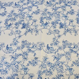 May include: White fabric with a blue and white repeating pattern of elephants, monkeys, and peacocks in a jungle setting.