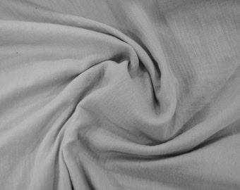 May include: A close-up of a light gray fabric with a soft, wrinkled texture. The fabric is smooth and appears to be made of a lightweight material.