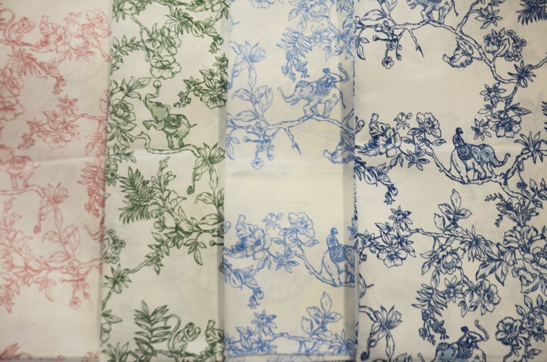 May include: Three fabric swatches with a white background and a repeating pattern of blue, green, and pink stylised elephants, birds, and flowers.