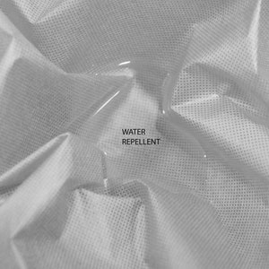 May include: A close-up of a white fabric with a fine grid pattern. A drop of water sits on the fabric, demonstrating its water-repellent properties. The text "WATER REPELLENT" is printed below the water drop.