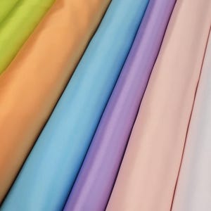 Puede incluir: Una colecci&oacute;n de seis muestras de tela en varios colores pastel, incluyendo verde lima, melocot&oacute;n, azul claro, lavanda, rosa y blanco.