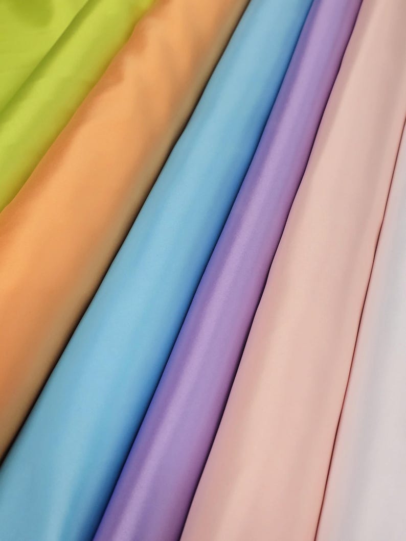 Puede incluir: Una colecci&oacute;n de seis muestras de tela en varios colores pastel, incluyendo verde lima, melocot&oacute;n, azul claro, lavanda, rosa y blanco.