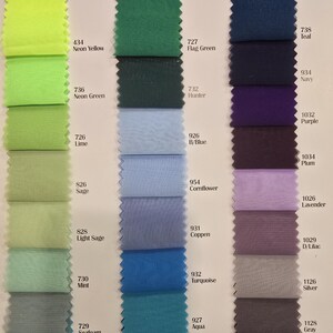 K&ouml;nnte beinhalten: Eine Farbkarte mit Stoffmustern in verschiedenen Gr&uuml;nt&ouml;nen, Blaut&ouml;nen, Violettt&ouml;nen und Graut&ouml;nen. Jedes Muster ist mit einer Nummer und einem Farbnamen gekennzeichnet.