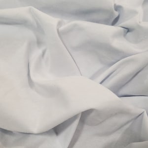 Peut inclure: Un tissu bleu clair avec une texture douce et lisse. Le tissu est pli&eacute; et drap&eacute;, cr&eacute;ant un sentiment de mouvement et de fluidit&eacute;.
