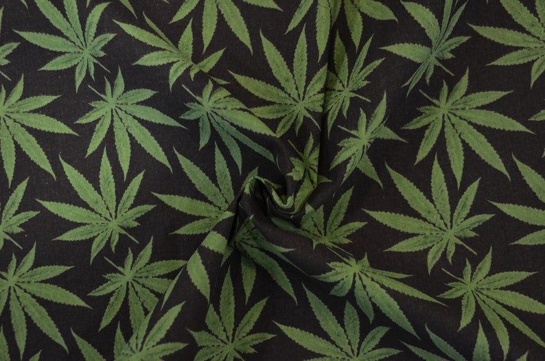 May include: Black fabric with a repeating pattern of green cannabis leaves.