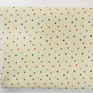 May include: Cream-colored fabric with a repeating pattern of small, colorful polka dots. The dots are in shades of red, yellow, green, and gray.