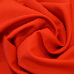 Puede incluir: Primer plano de una tela de color rojo brillante, que muestra la textura y los pliegues del material.