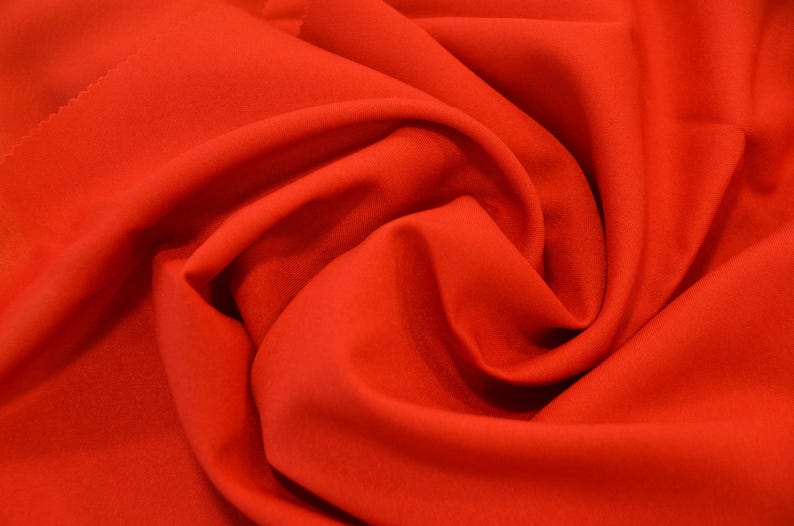 Puede incluir: Primer plano de una tela de color rojo brillante, que muestra la textura y los pliegues del material.