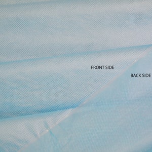 May include: Close-up of a light blue fabric with a fine, textured pattern. The fabric is folded in half, with the words "Front Side" and "Back Side" labeled on the two sides.