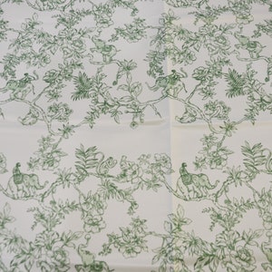 May include: White fabric with a repeating pattern of green leafy branches, flowers, and elephants with riders. The elephants are facing left and right.