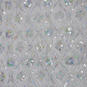 May include: Silver fabric with a repeating pattern of iridescent sequins. The sequins are arranged in a geometric design with a floral motif.